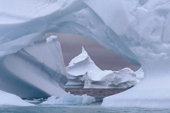 Pointed iceberg seen through a hole in an iceberg near Pleneau Island. Antarctic Peninsula