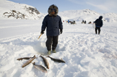 Joavee Alivakluk, an Inuit hunter, fishing through a hole in the ice for Arctic Char on a frozen lake near Pangnirtung. Nunavut, Canada. 2008