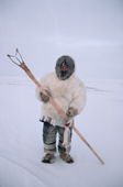 Aipilik, an Inuk hunter in fox furs with Kakivak (Inuit fish spear) & fish. Igloolik, Nunavut, Canada. 1993