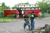 Local youths on bicycles near a shop made from a boat in Puerto Ayora, Santa Cruz, The Galapagos Islands