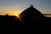 Two Chukchi Yarangas (traditional tents) silhouetted by the setting sun at a reindeer herder's summer camp. Iultinsky District, Chukotka, Siberia, Russia.
