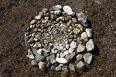 A circular pattern of small stones on the ground at a Chukchi reindeer herder's camp symolises the reindeer herd. The Chukchi believe that these carefully selected & positioned stones will help keep the actual reindeer herd healthy and their number will increase. Iultinsky District, Chukotka, Siberia, Russia