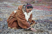 At the end of the Chukchi Festival of Young Reindeer', Rita Votgyrgina, collects small stones to place on burial mound (Melgynvyn), where the powdered bones of sacrificed reindeer are buried, close to the family's Yaranga (tent). Iultinsky District, Chukotka, Siberia, Russia