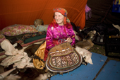 Pavla Nogo, a Komi woman, sits with her reindeer skin sewing bag inside her tent. Yamal, Northwest Siberia. Russia.