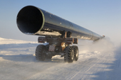 A truck carrying a large section of gas pipe on a winter road near the Yurharovo gas field. Noviy Urengoi, Yamal, Western Siberia, Russia.