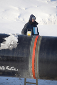 A worker checking a seam on a section of a gas pipeline with an X-Ray Defectoscope being during the winter near the Yurharovo gas field. Noviy Urengoi, Yamal, Western Siberia, Russia.