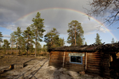 A rainbow over a log cabin at a Selkup camp in the forest. Krasnoselkup, Yamal, Western Siberia, Russia