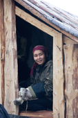 Rita Morokova, a young Selkup woman, sorting winter clothing in the storage area above a log cabin at a summer camp in the forest. Krasnoselkup, Yamal, Western Siberia, Russia.