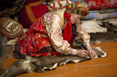 Marina Valeeva, a Komi woman, prepares to cut a pattern from a reindeer skin on the floor of her tent, which she will use to make a coat for her daughter. Yamal, Western Siberia, Russia