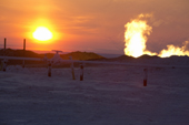 The winter sun sets behind a gas flare at a drilling site in the South Tambey gas field. Yamal Peninsula, NW Siberia, Russia