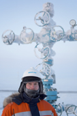 Evgeniy Petrov, a safety officer for Yamal SPG, stands infront of a 'Christmas tree' (valve assembly) at a drilling site in the South Tambey gas field. Yamal Peninsula, NW Siberia, Russia