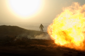 A gas field worker walks near a flare at a drilling site in the South Tambey gas field. Yamal Peninsula, NW Siberia, Russia