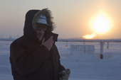 At dusk, foreman, Vladimir Ermark, talks on his radio during a visit to a drilling site near Sabetta. South Tambey gas field. Yamal Peninsula, NW Siberia, Russia