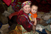 Marina Valeeva, a young Komi woman, holds her six month old baby daughter, Tonya, inside her family's tent at a winter camp in the forest. Priuralsky District, Yamal, NW Siberia.
