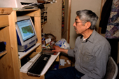 Clifford Weyiouanna checks the location of his reindeer herd on his computer. 5 of his reindeer have satellite collars. Shishmaref. Alaska. 2003