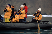 Yellow jacketed tourists paddle the zodiac in Dundas Harbour. Baffin Island. Canadian Arctic. 2002
