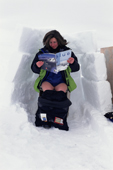 Visitor to the Arctic uses an outdoor toilet screened from the wind by a wall of snowblocks. Nunavut. Canada. 1999