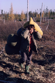 A Cree woman carries bedding and goods on a portage between waterways. Quebec. Canada. 1988