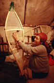 A Cree woman, Elizabeth Brien, threads caribou hide lacing onto a pair of snowshoes. Quebec, Canada. 1988