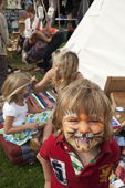 Children gravitate to the face painter at the Sturminster Newton Cheese Festival. Dorset. England