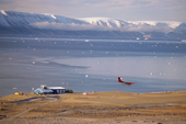 Plane comes in to land at the new airport at Qaanaaq, overlooking Inglefield Bay. Thule, Northwest Greenland.