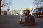 Sewer worker emerges from a manhole cover in the Mall in front of Buckingham Palace. London. England.