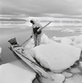 Jess Qujaukitsok prepares to get into his kayak from the ice, Inglefield Bredning. Thule, Northwest Greenland. 1971
