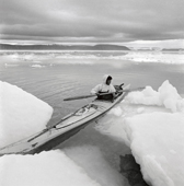 Jess Qujaukitsok paddles his kayak round some tidal ice floes in Inglefield Bredning. Thule, Northwest Greenland. 1971