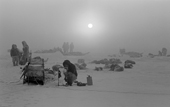 Freezing fog enshrouds a group of Inuit hunters as they stop for a tea break on sea ice near Pitoraavik. Northwest Greenland. 1977