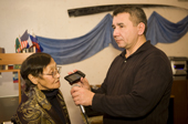 Ainana, an elderly Yupik Eskimo woman speaks into a mobile phone, held by Edward Zdor, being used during a conference with native Eskimos in Alaska. Provideniya, Chukotka, Siberia, Russia. 2010