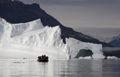 Dramatic light on icebergs and zodiacs. Rdefjord, Scoresbysund, East Greenland