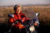 Older woman Biker on Honda Rebel wearing a red leather jacket in the Desert in New Mexico. USA